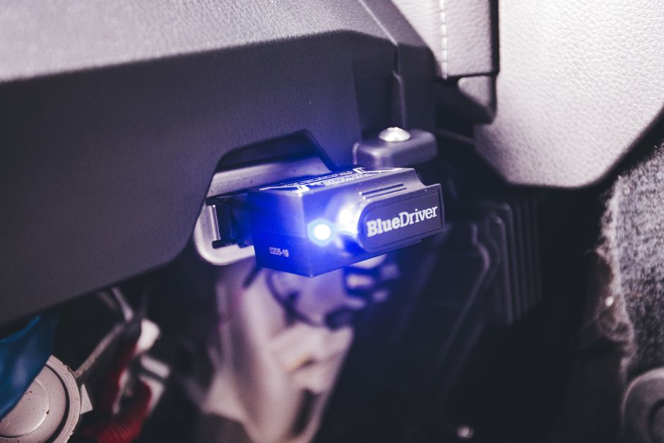 Technik so skenerom pripojeným k OBD konektoru pri diagnostike vozidla
